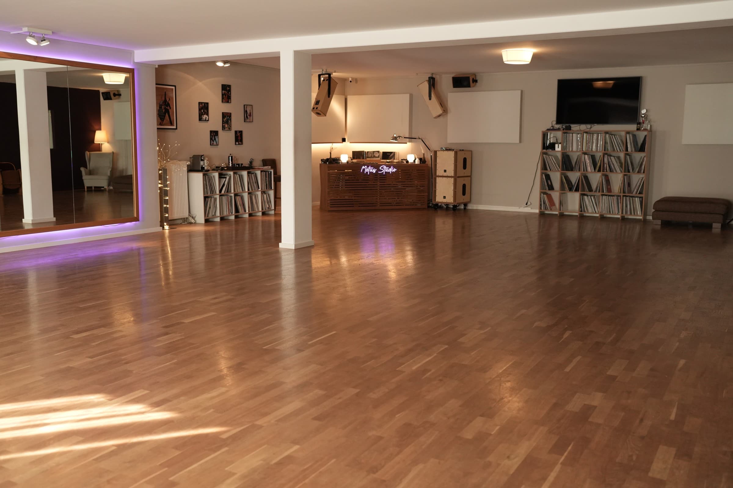 Motus Studio mit Parkett, beleuchteter Spiegelwand und Musikbereich