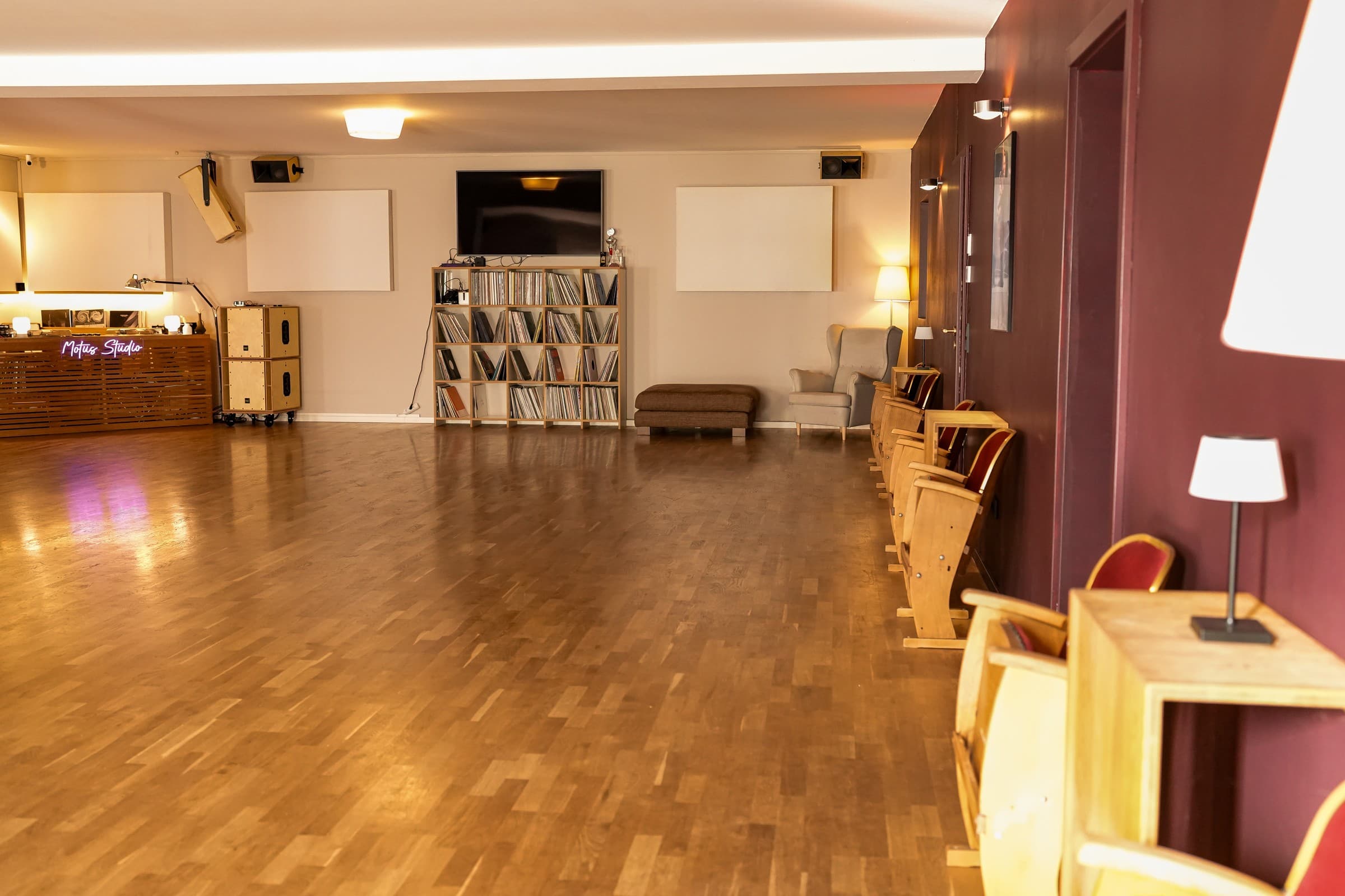 Gemütliche Sitzecke mit Sessel, Holztischen und Schallplatten im Motus Studio